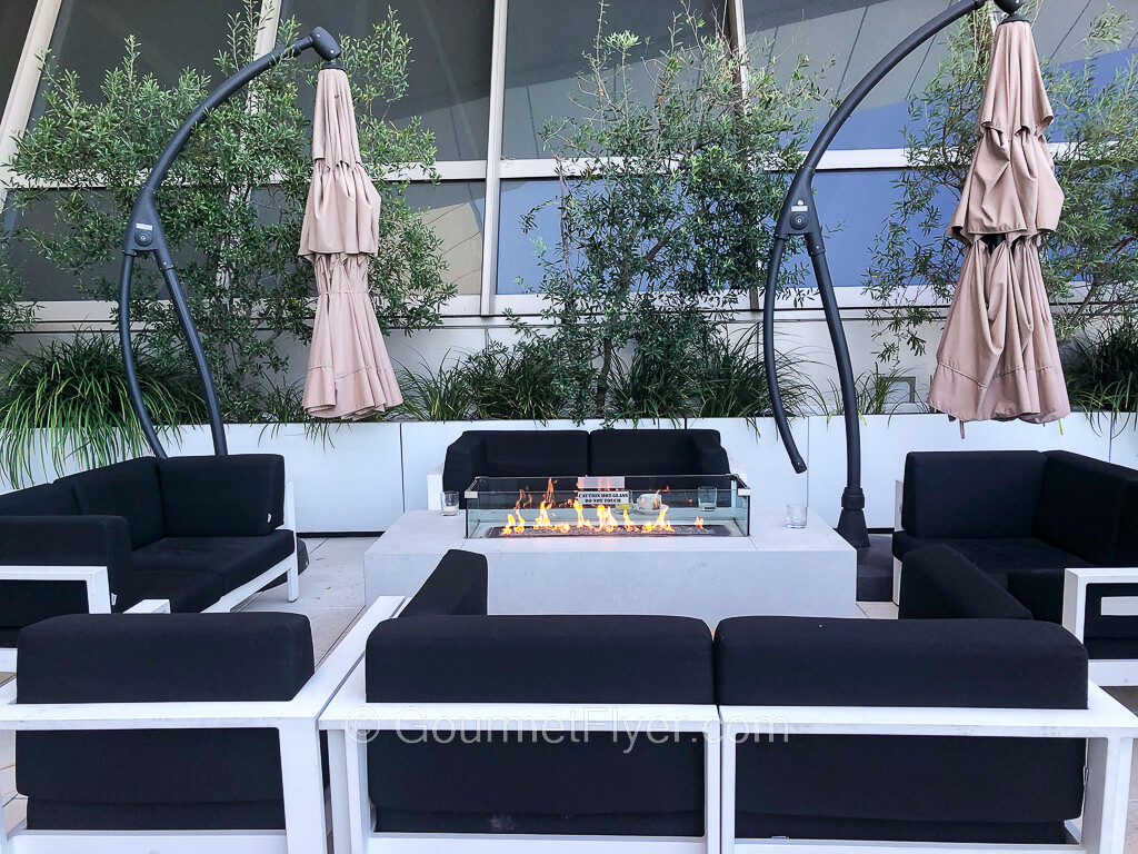 Four sofas are placed in a rectangle surrounding a fire pit.