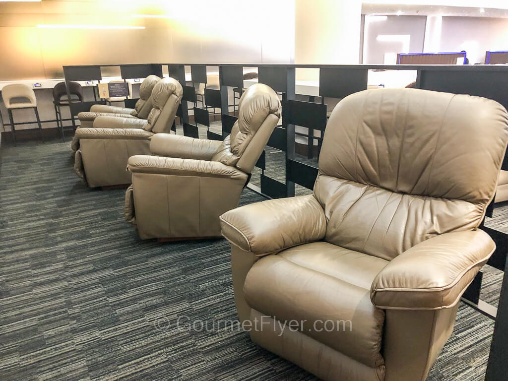 A rest area is equipped with four large leather recliner chairs.