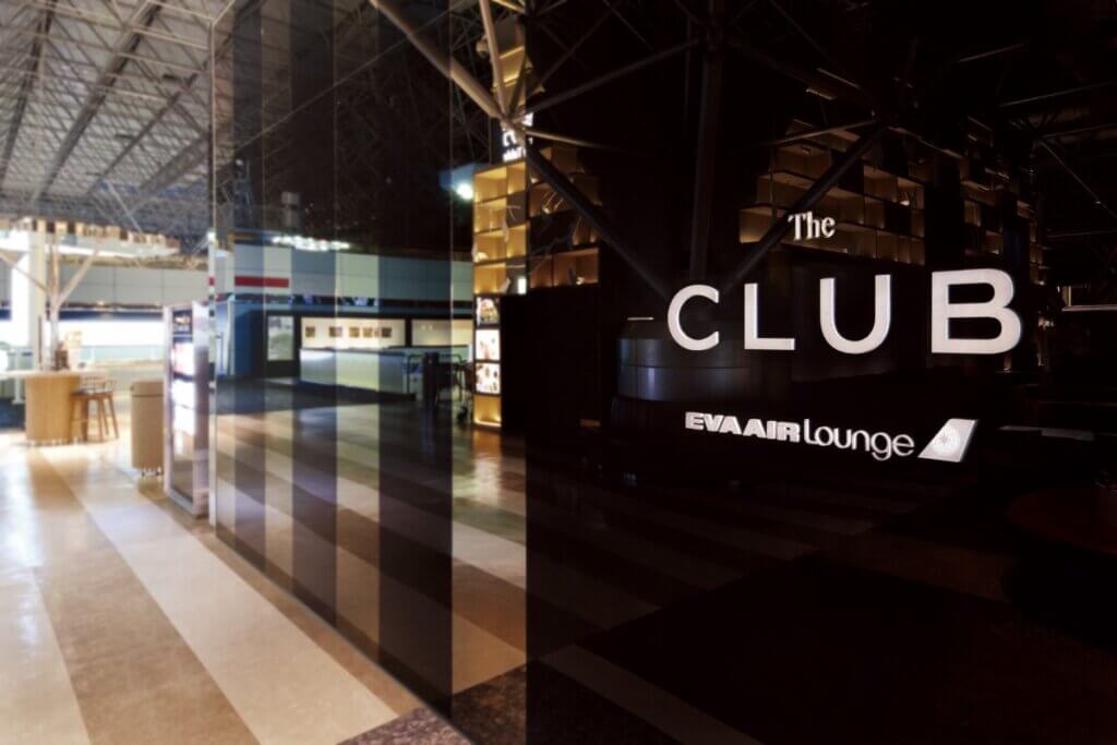An elegant sign of "The Club EVA Air Lounge" is written in white letterings on a black marble surface.