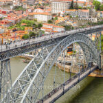 The one-day in Porto walking tour features tourists walking on both the upper and lower decks of the arched Dom Luis I Bridge across the river.