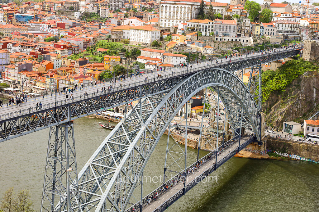 The one-day in Porto walking tour features tourists walking on both the upper and lower decks of the arched Dom Luis I Bridge across the river.