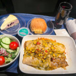 United's domestic first-class menu features a plate of beef enchiladas served with a green salad and a glass of red wine.