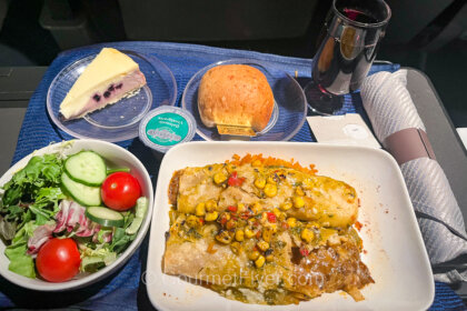 United's domestic first-class menu features a plate of beef enchiladas served with a green salad and a glass of red wine.