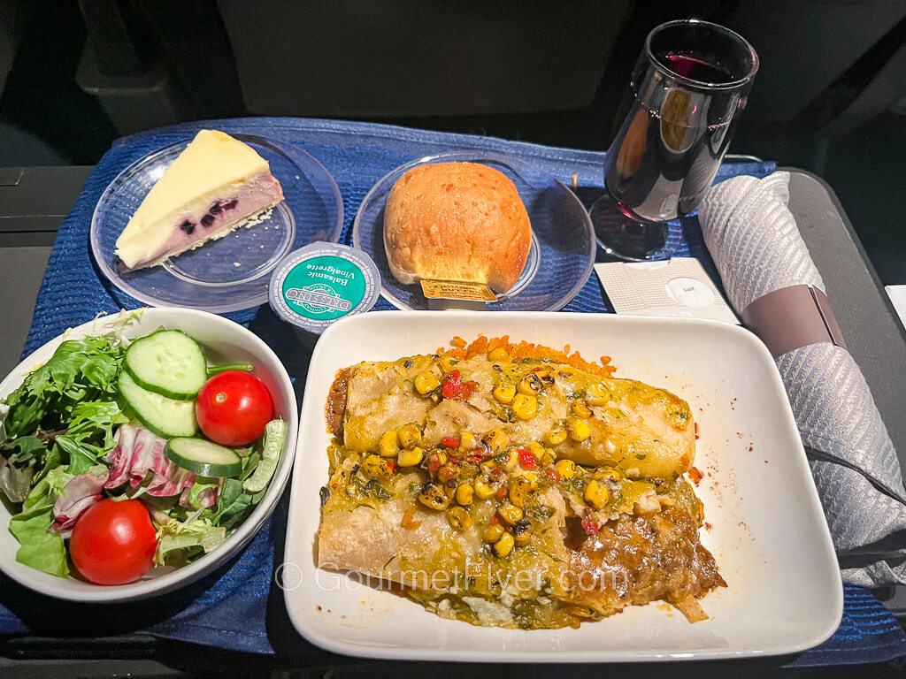 United's domestic first-class menu features a plate of beef enchiladas served with a green salad and a glass of red wine.