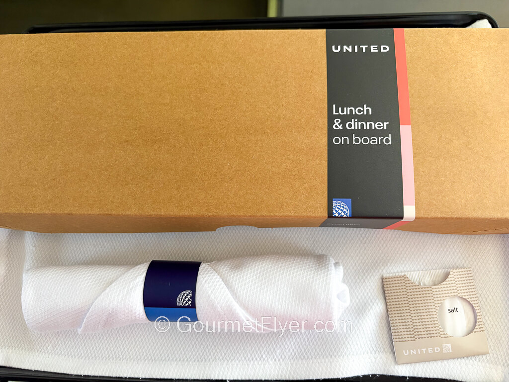 A long rectangular cardboard box has United's logo and the label for lunch and dinner.