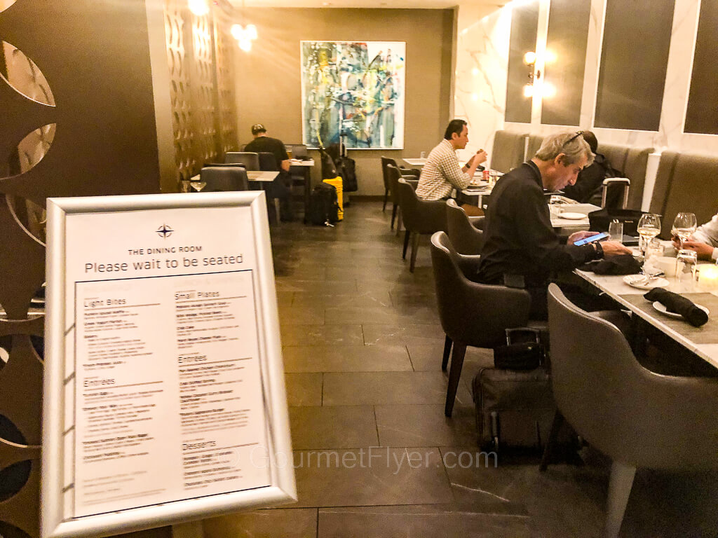 Several diners are enjoying their meals at various tables inside a restaurant.