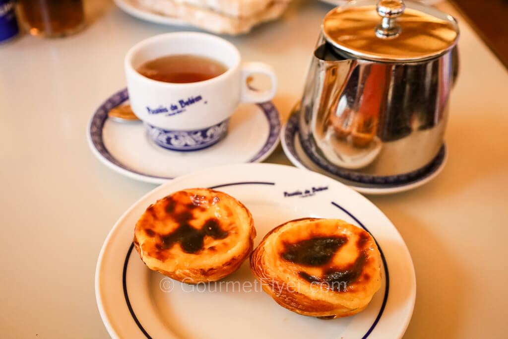 Five most iconic places to eat in Lisbon featured an afternoon tea set with two classical egg tarts accompanied by a silver teapot.