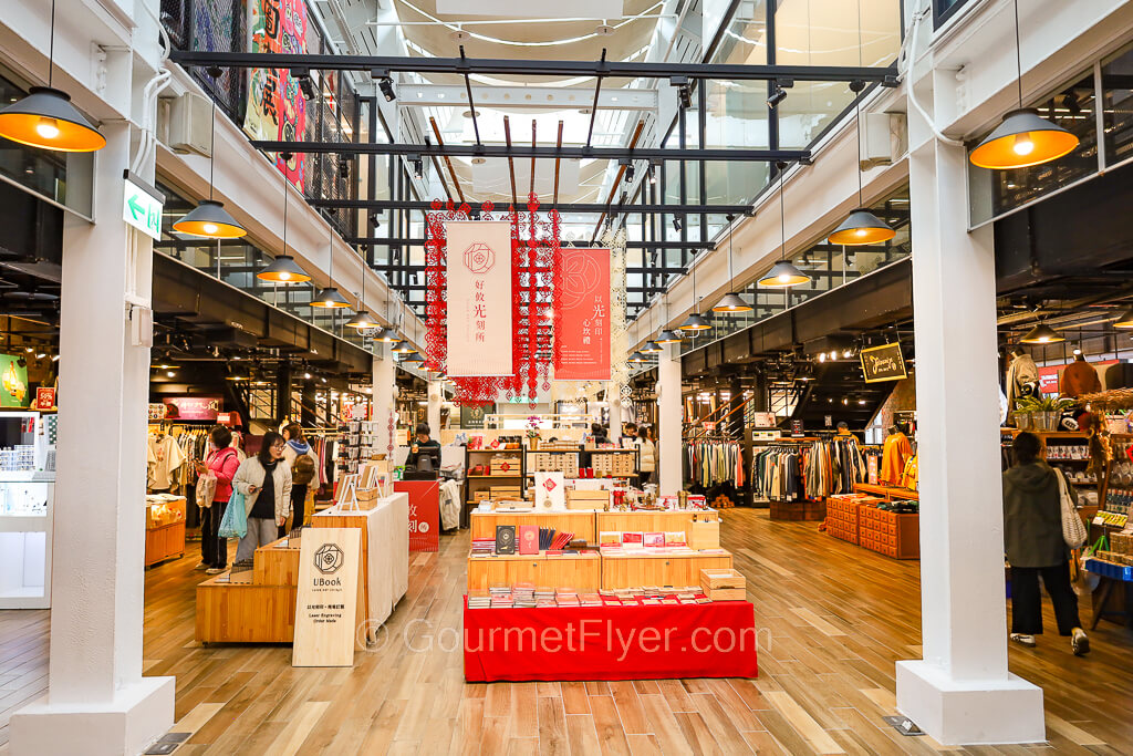 Shoppers are browsing around a variety of stores spread throughout an interior hall.