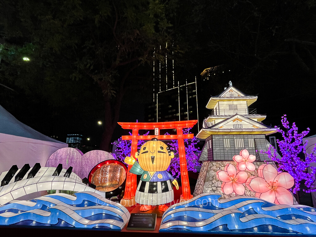 A Japanese themed display features a man wearing a piano shirt with a castle in the background.