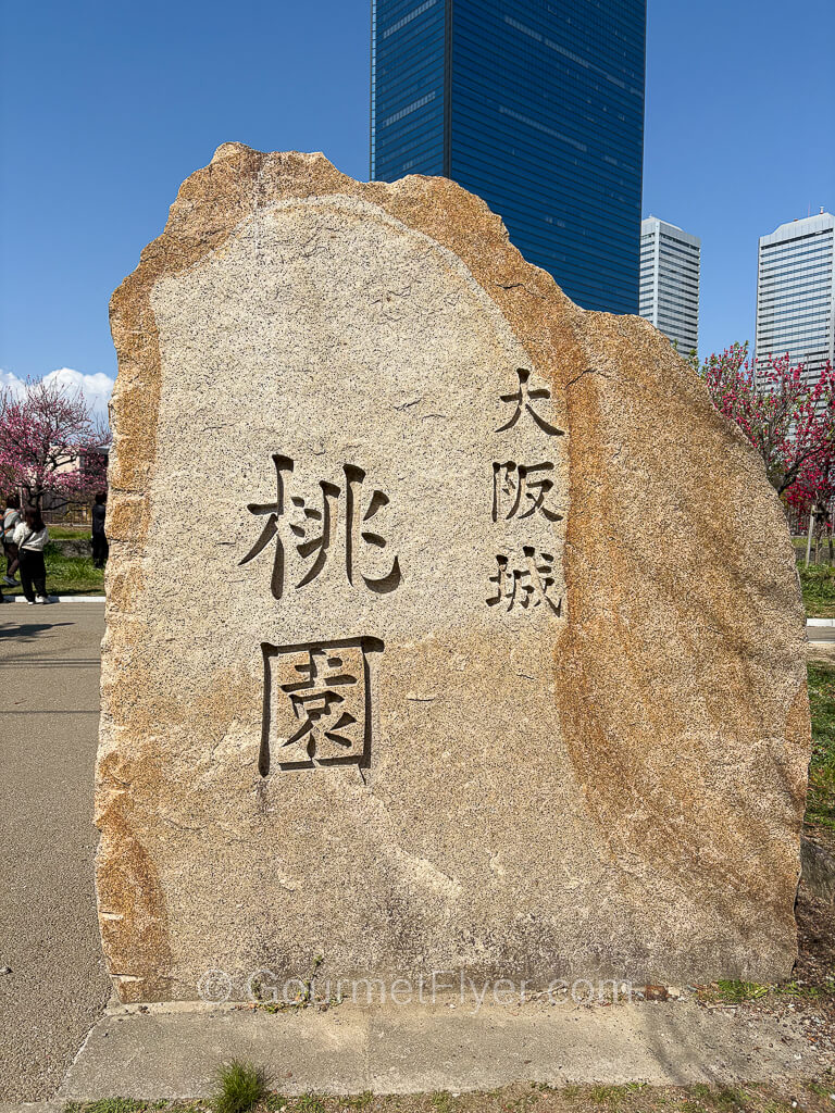 A stone with peach grove written in Japanese kanji characters inscribed on it.