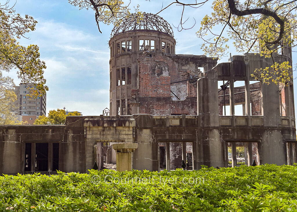 The skeletal ruins of a domed building stands under sunny blue skies.