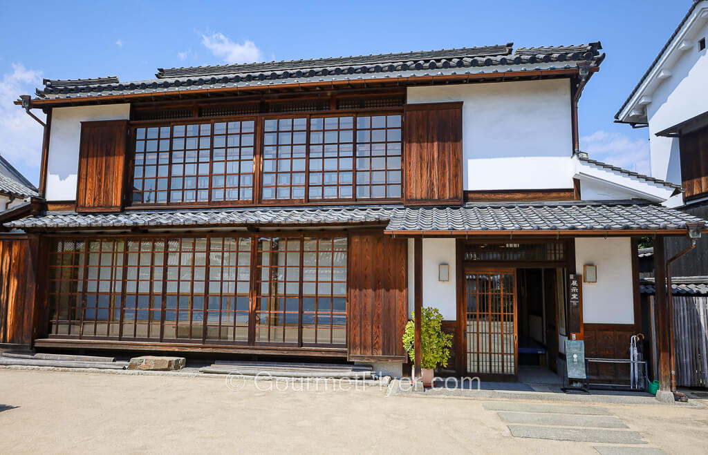 A large traditional Japanese two-story residence with wooden framed doors and windows.