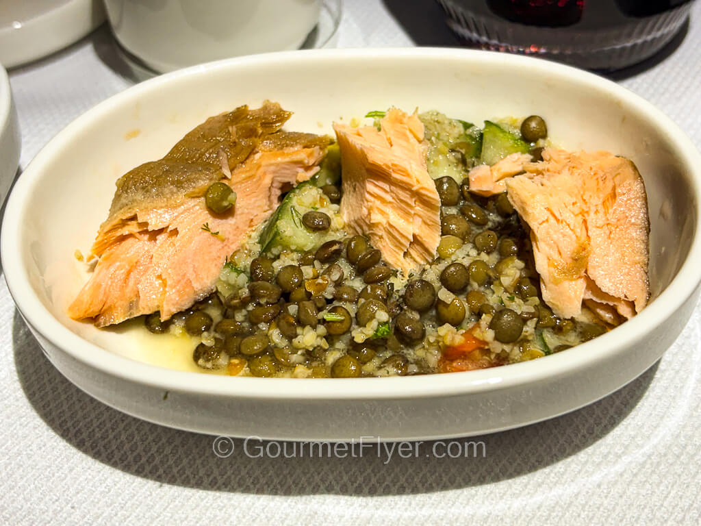 A fish dish is accompanied by lentil beans and plenty of garlic.