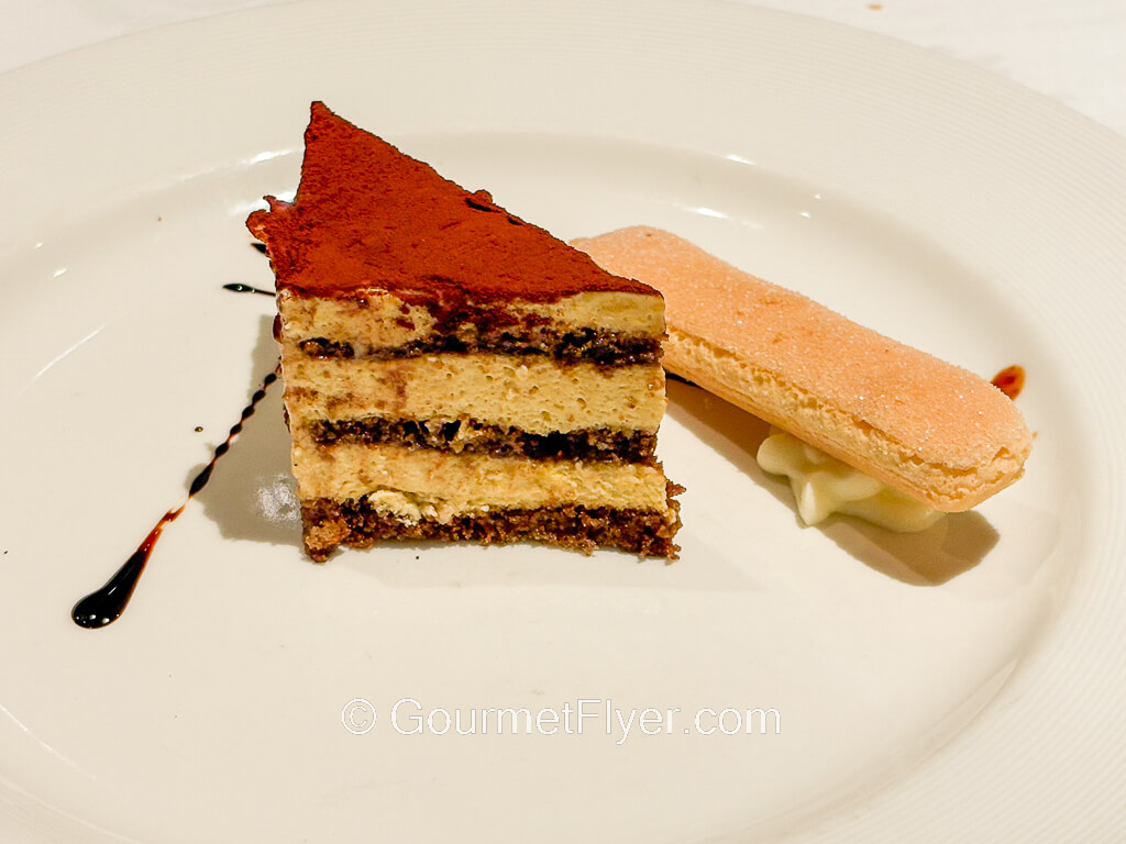 A triangular wedge of cake is sprinkled with cocoa powder.