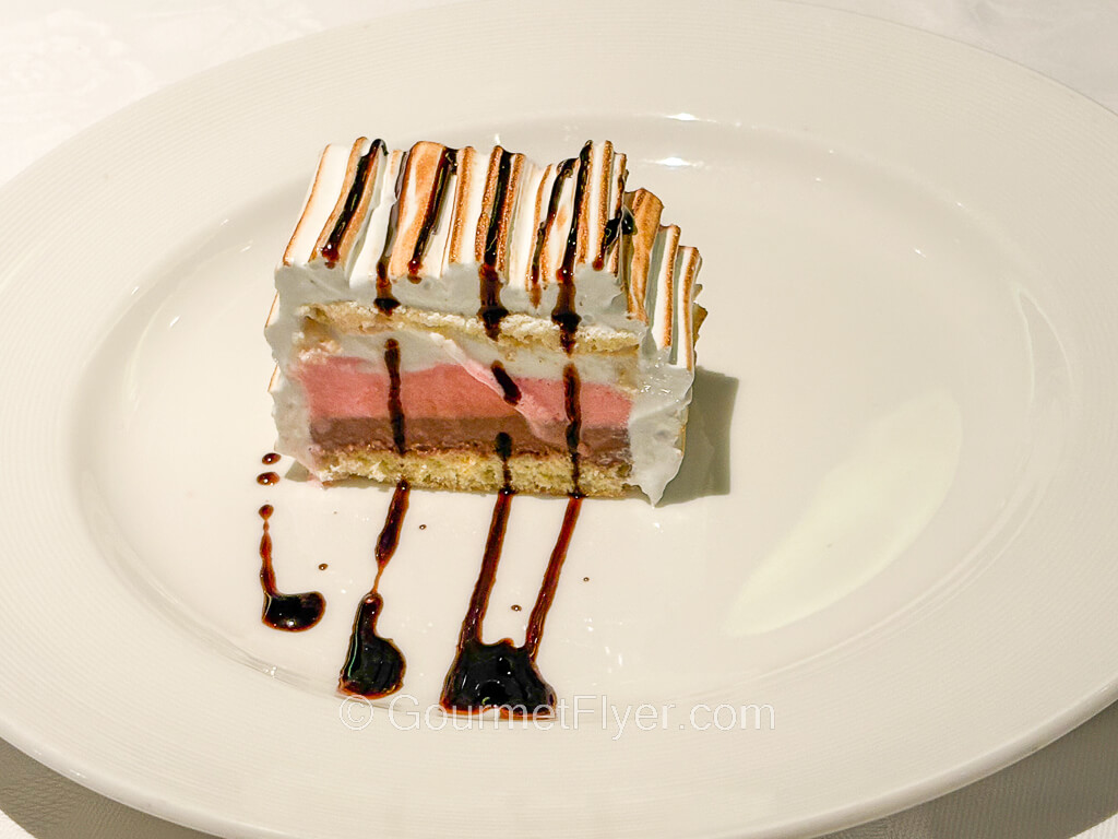 A ice cream cake is made of three layers, vanilla, strawberry, and chocolate.