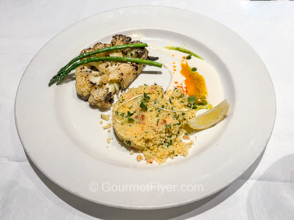 A vegetarian dish consists of cauliflower, beans, and carrots.