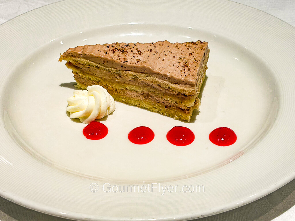 A slice of cake is decorated with red syrups in circles