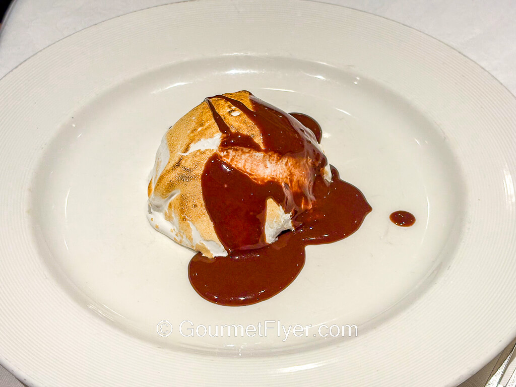 An ice cream sundae is covered with plenty of chocolate syrup and whipped cream.