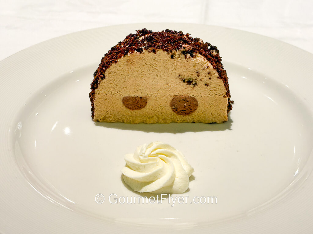 A slice of chocolate cake is presented vertically.