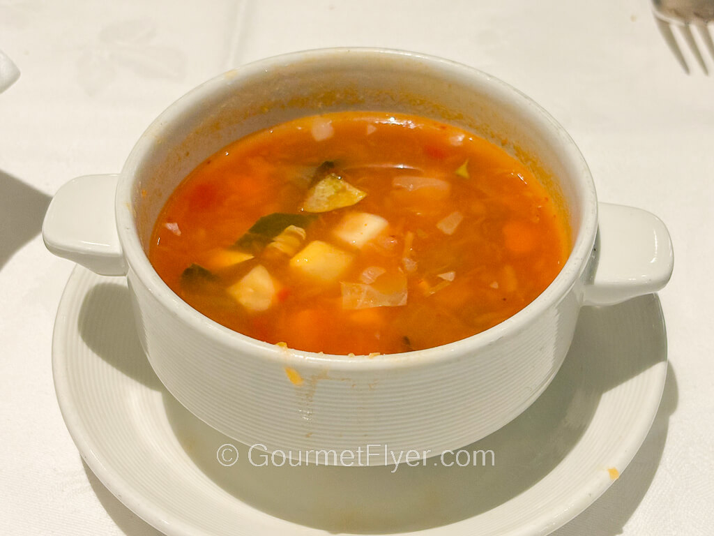 A bowl of red tomato-based vegetable soup.