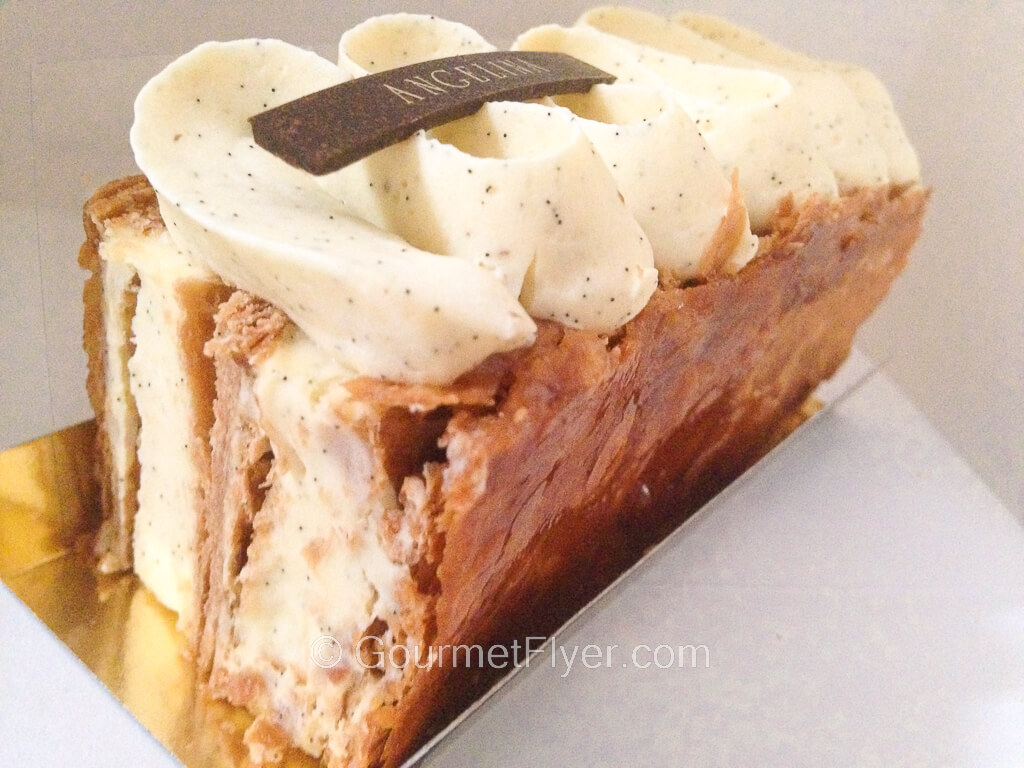 A piece of cake filled with lots of cream sandwiched between crunchy crusts bears the Angelina logo on top.