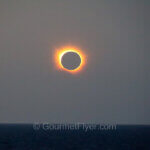 A total solar eclipse viewing on the Enchanted Princess cruise features the bright orange corona on the outer rim of the moon.