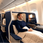The Fare-Rule Traps That Catch Business Class Travelers Off Guard features a man sitting in a lie-flat seat on a commercial flight.
